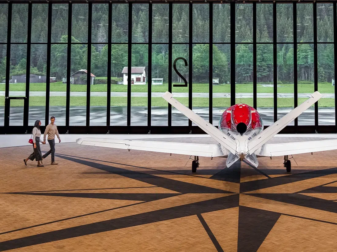 An image of a couple walking across a hangar towards a stationary VisionJet